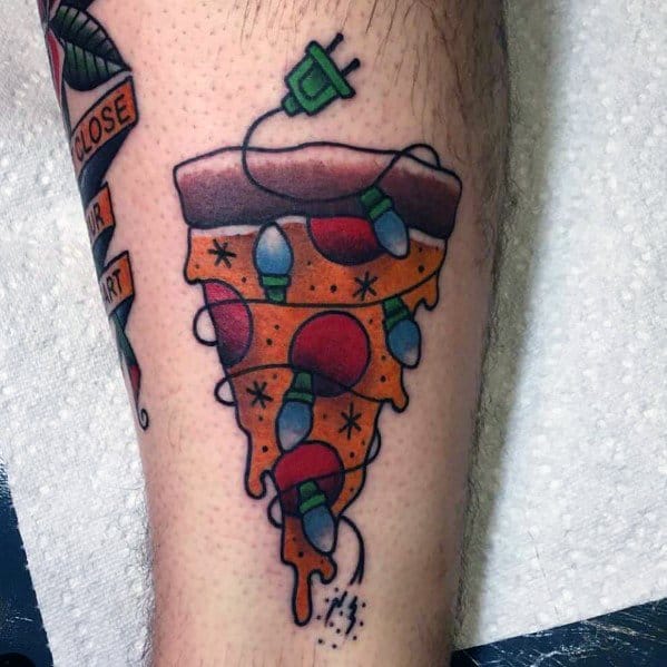 Christmas tattoo of a slice of pizza decorated with holiday lights and ornaments, featuring a plugged-in cord for a fun and festive twist on a classic design.