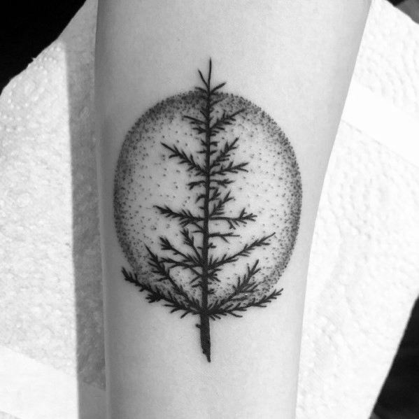 Minimalist Christmas tree tattoo with fine dot shading inside a circular background, creating a stylish and modern design on the forearm.