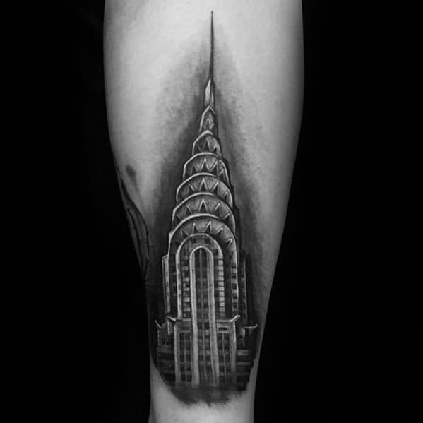 Realistic black-and-grey Chrysler Building tattoo with bold shading and fine details, creating a striking architectural design.
