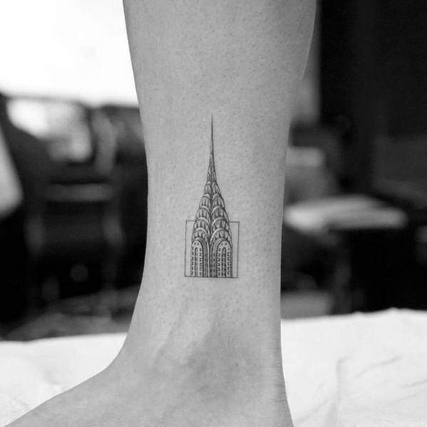 Minimalist Chrysler Building ankle tattoo with fine linework and geometric framing, creating a sleek and subtle architectural design.