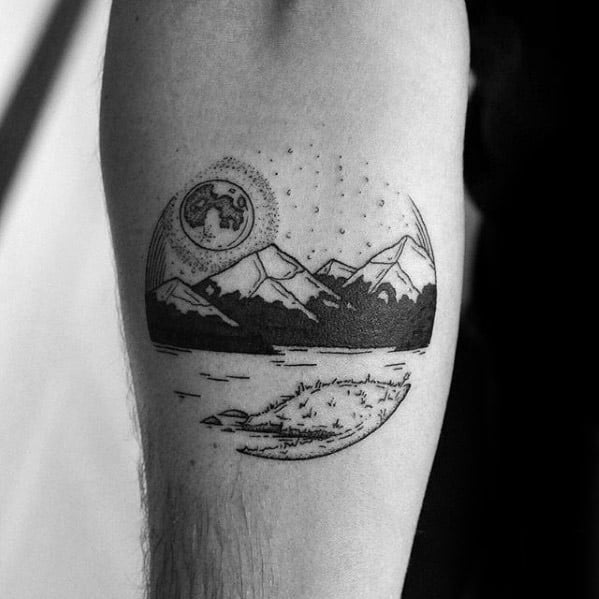 Minimalist lake tattoo with crescent moon, mountain range, and pine trees reflected in still water under a dotted night sky.