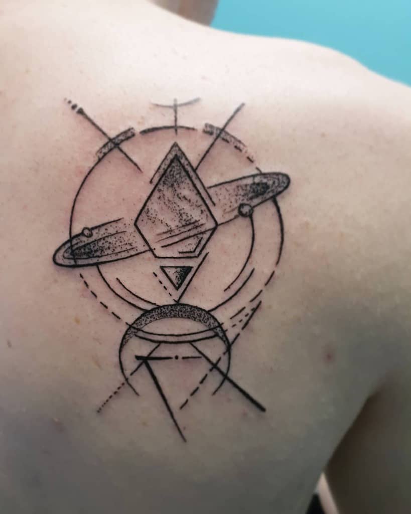 Back tattoo featuring a geometric planet with rings, abstract lines, and dot work, creating a futuristic and cosmic-inspired design.