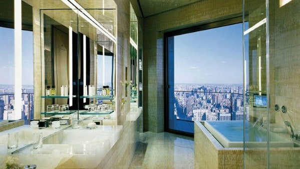 Luxurious bathroom with mirrored walls and city view through a large window