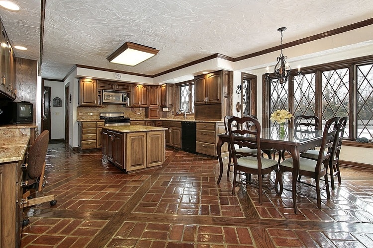 A classic kitchen with textured ceilings, wooden cabinetry, a spacious layout, and large windows providing natural light, creating a warm and inviting atmosphere
