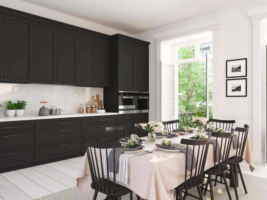 Classic kitchen with black cabinets, white countertops, and a dining table set with floral decor.