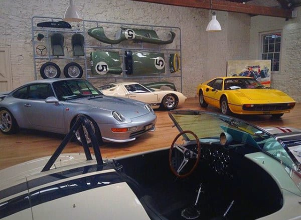 Classic car collector’s garage with vintage Porsche, Ferrari, and retro décor for ultimate nostalgia.