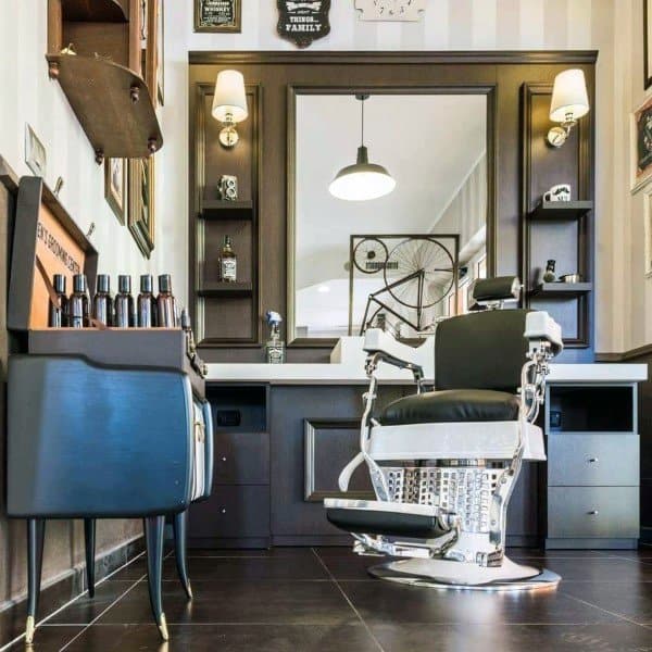 Elegant barber station with a vintage chair, wall mirror, shelves, and decorative accents.