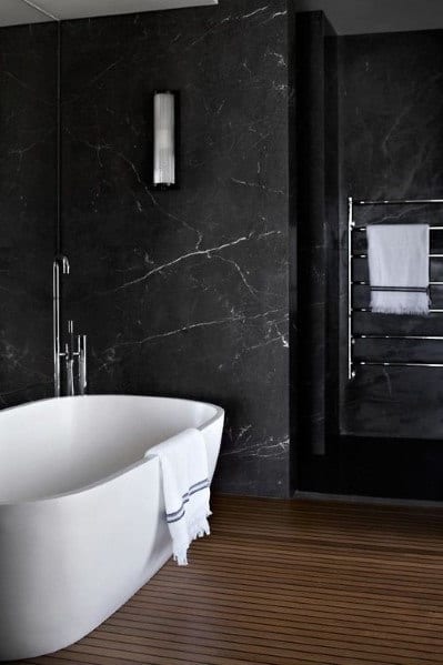 Minimalist bathroom with a white freestanding bathtub and dark marble walls