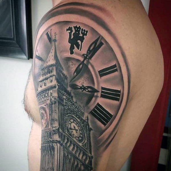 Detailed black and grey tattoo of Big Ben on the shoulder, with the clock face and a lion emblem, capturing a blend of architectural and symbolic elements.