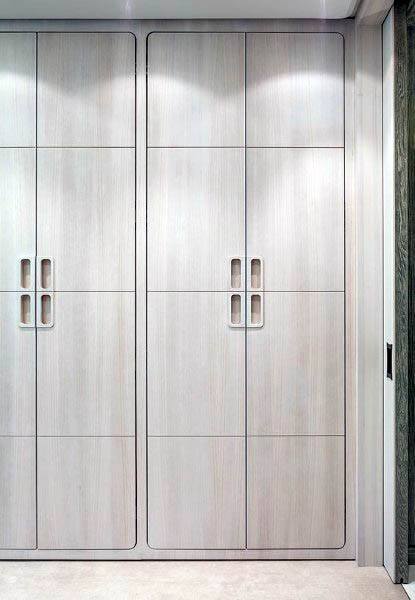 Modern wooden closet with sleek lines and minimalist handles, perfectly set against a light-colored wall