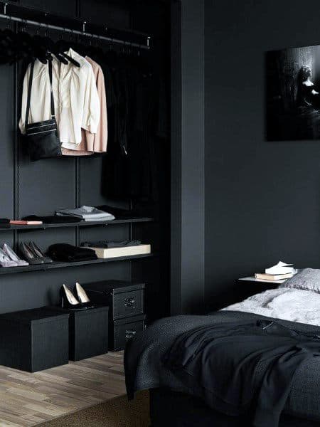 Dark bedroom with minimalist open closet, shelves, and storage boxes.