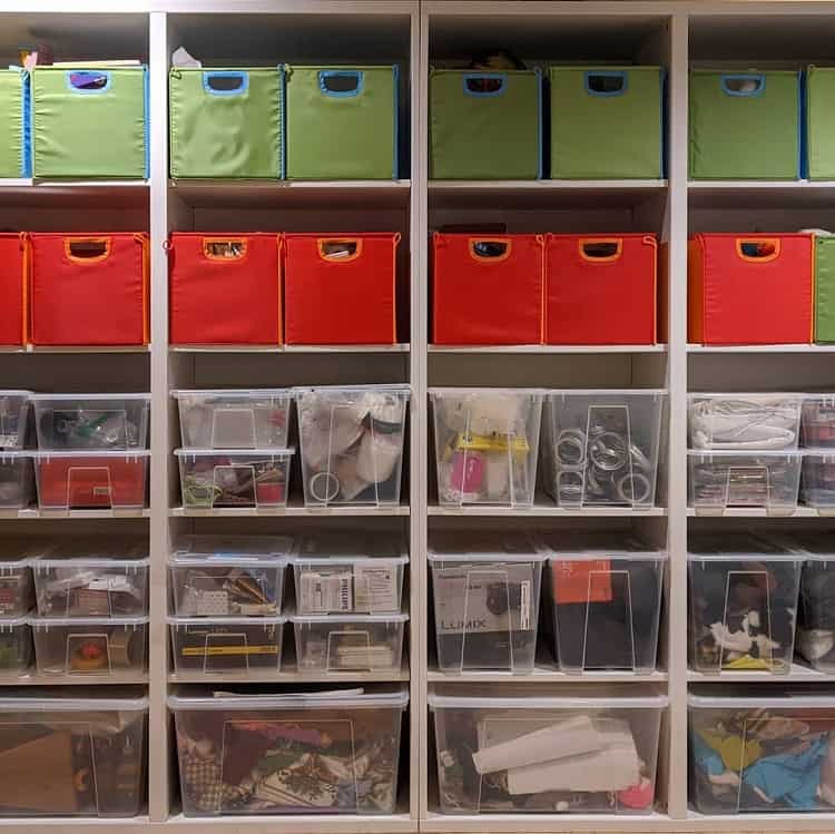 Shelves with colorful cloth bins and clear plastic bins for organized storage in basement.