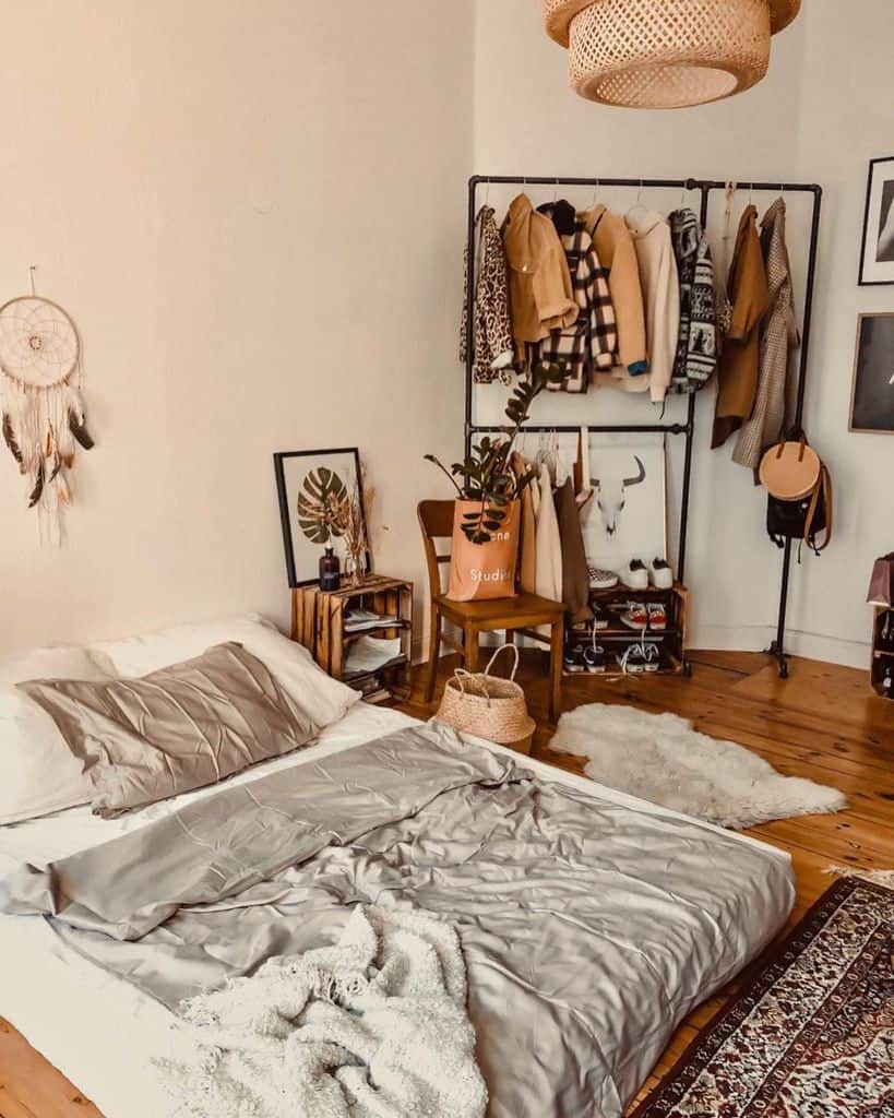 Rustic bedroom with metal clothes rack, wood floors, and cozy decor.