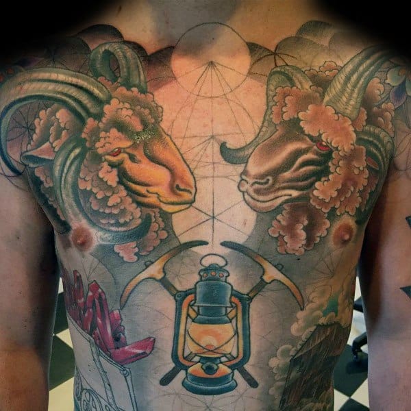 Colorful chest tattoo featuring two rams, a mining lantern, crossed pickaxes, and geometric patterns in the background.