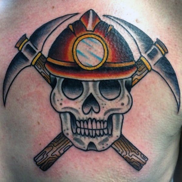 Colorful tattoo of a skull wearing a miner's helmet with two crossed pickaxes behind it in a bold, traditional style.