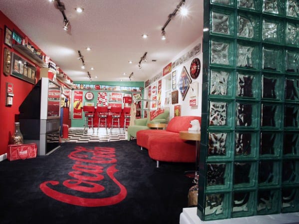 Retro diner-style man cave with Coca-Cola decor, red seating, vintage signs, and green glass blocks on the right