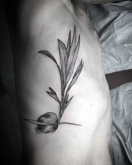 Minimalist black line tattoo of a young coconut sprouting long palm leaves, placed on the side ribcage.