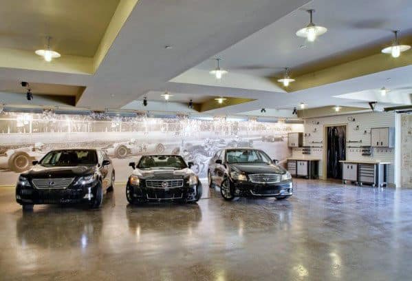 Garage with coffered ceiling, polished floors, luxury cars, and a vintage racing mural.