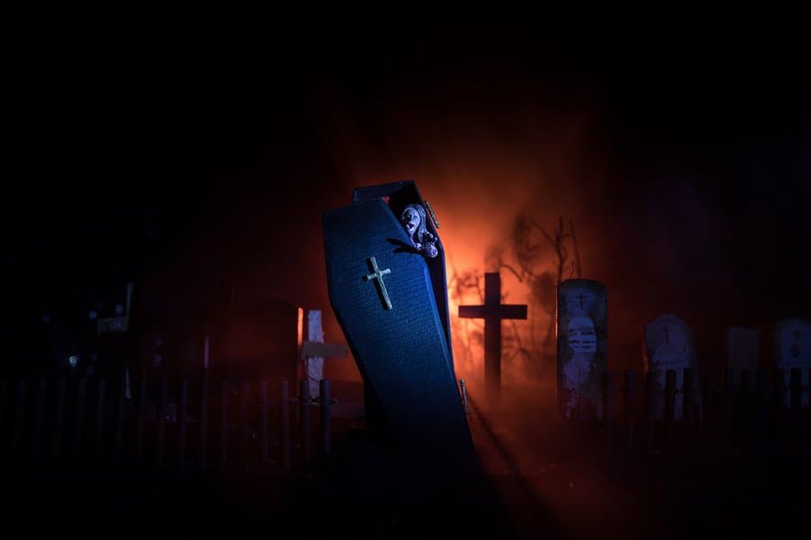 coffin with zombie inside at cemetery