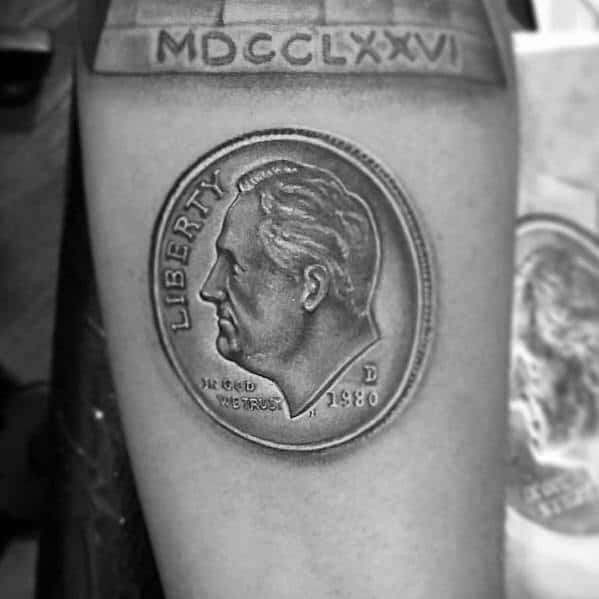 Detailed tattoo of a 1980 Roosevelt dime on the forearm, featuring realistic shading and 'MDCCLXXVI' in Roman numerals above