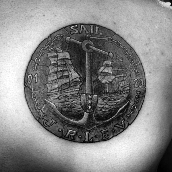 Detailed tattoo of a nautical-themed coin featuring an anchor, sailing ships, and chain border, symbolizing adventure and maritime heritage.
