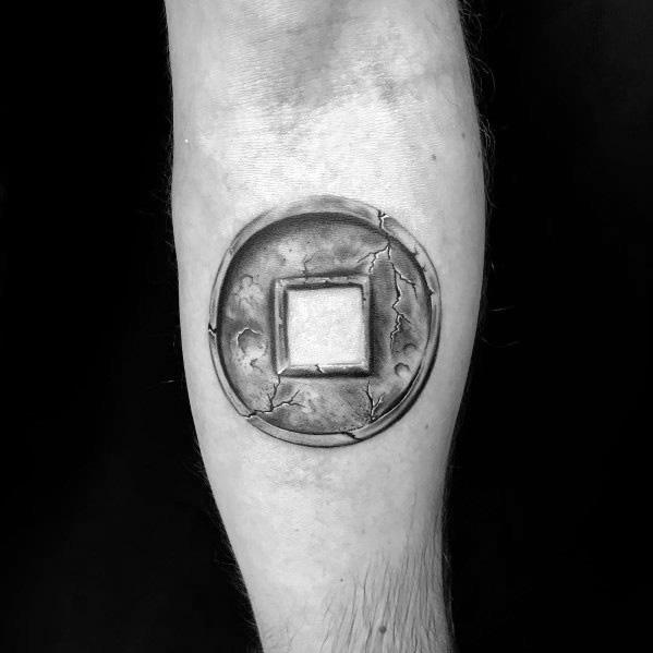 Realistic tattoo of an ancient Chinese coin with a square hole, featuring worn edges and cracks for an authentic aged appearance.