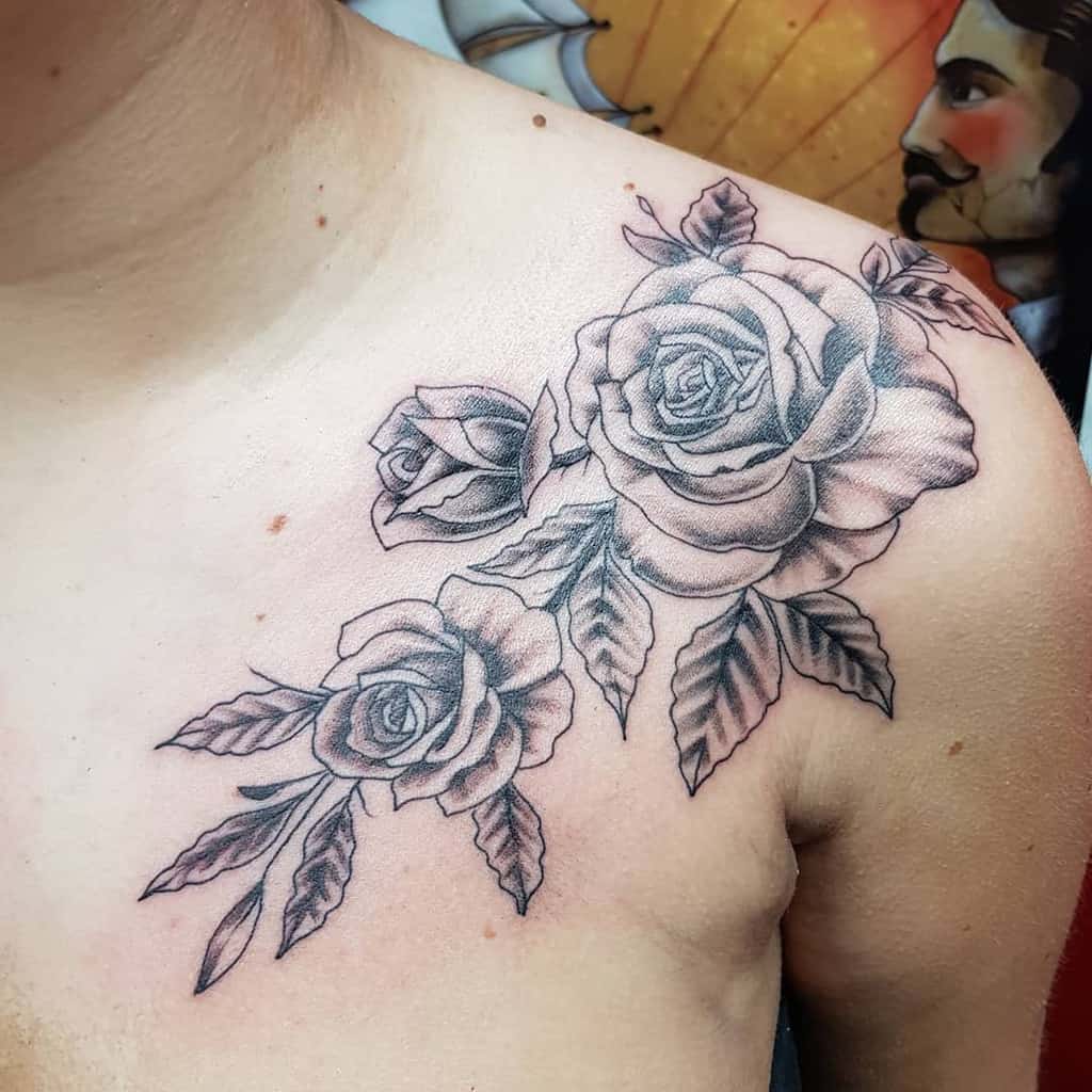 A gracefully inked tattoo of roses and leaves adorns the shoulder, elegantly capturing nature’s beauty