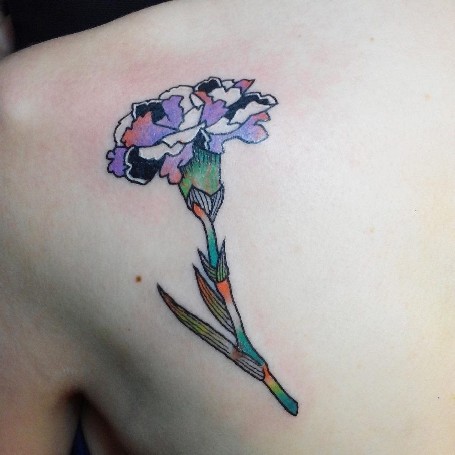 A colorful carnation tattoo on someone's shoulder blade