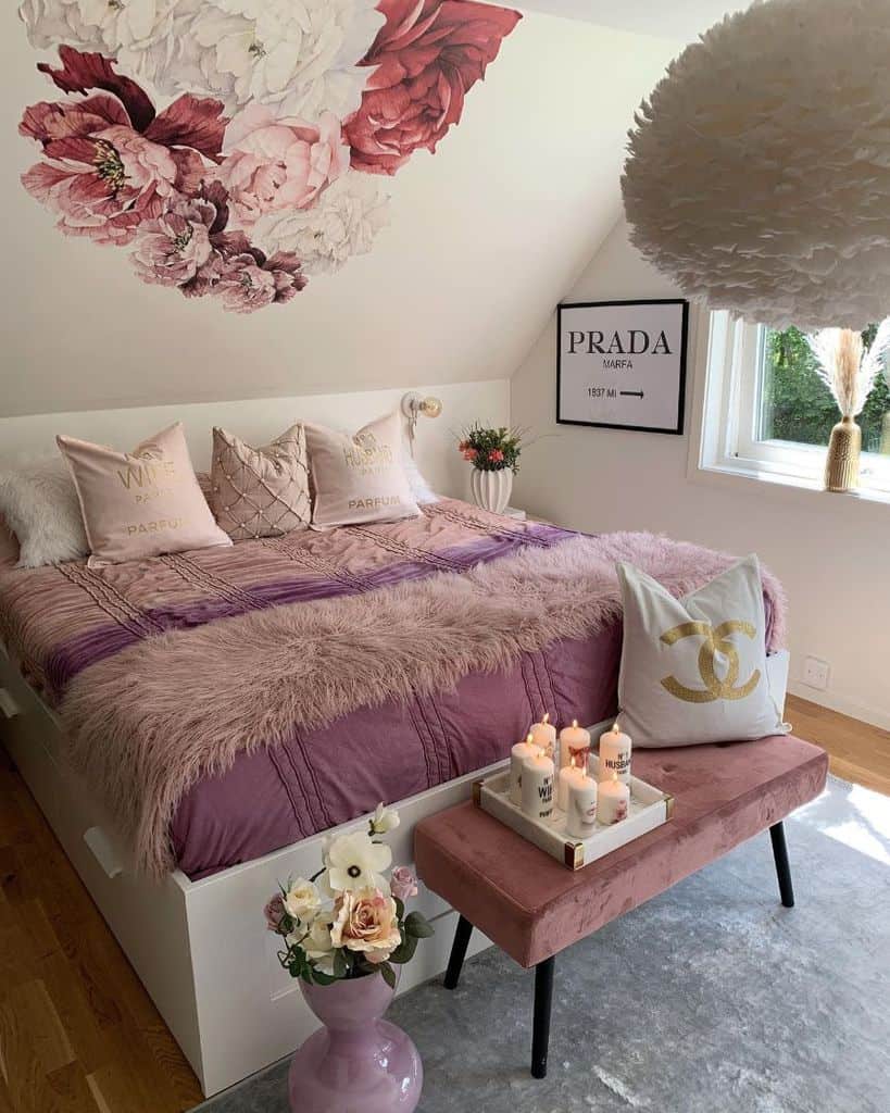 Paris-inspired bedroom with floral wall art, pink bedding, candles, and decorative pillows.