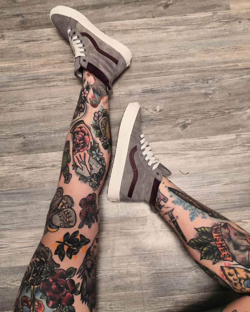 Colorful tattoo leg sleeves, featuring a variety of designs including roses, skulls, hands, and swords