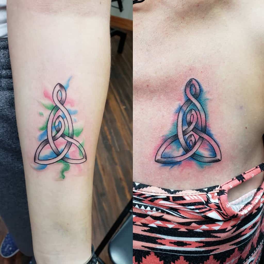 Colorful Celtic knot mother-daughter tattoo in black and vibrant watercolor hues, with soft blue, green, and pink splashes