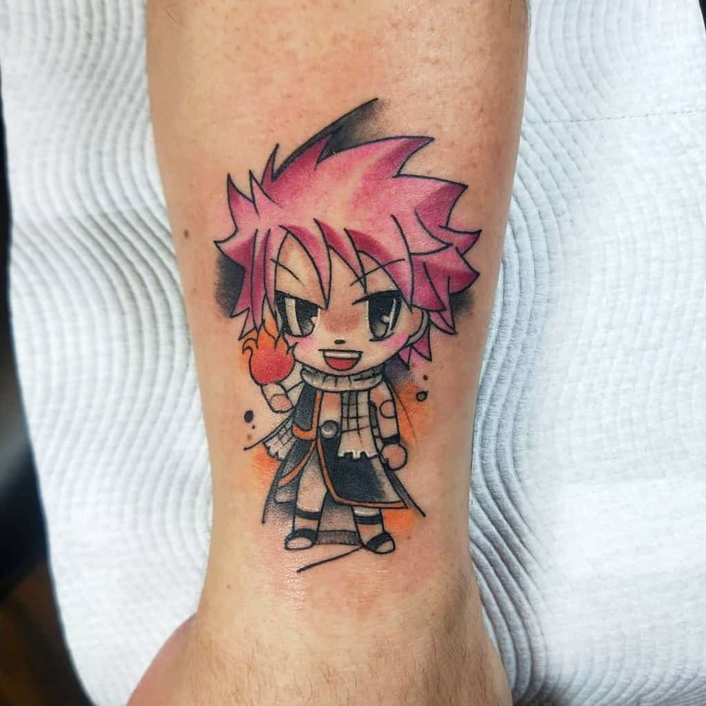 Chibi-style tattoo of Natsu Dragneel from Fairy Tail on the wrist, featuring vibrant pink hair, a playful expression, and fiery details.