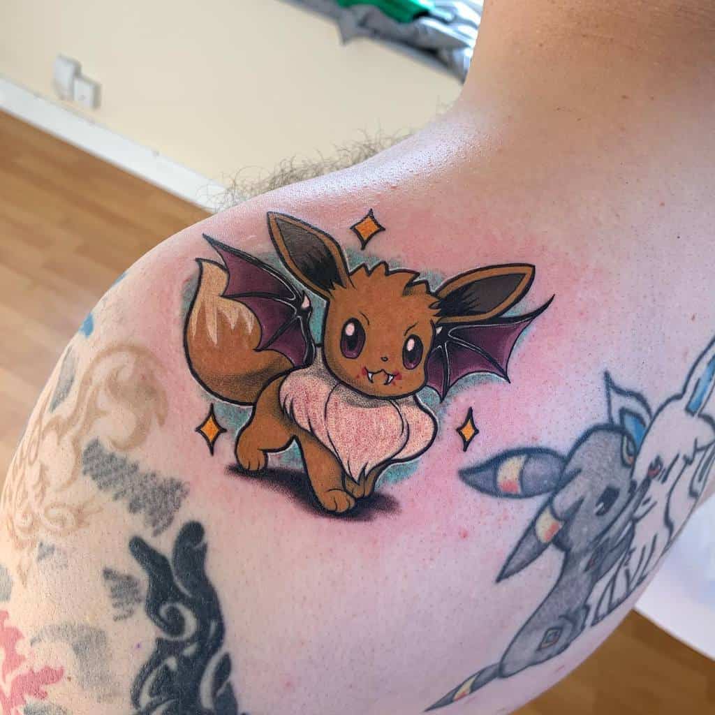 Adorable vampire Eevee tattoo with bat wings, fangs, and sparkles, adding a playful and spooky touch to the design