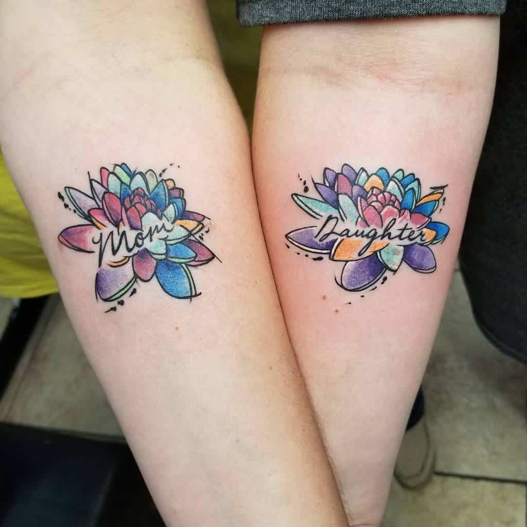 Matching mother-daughter tattoos of watercolor lotus flowers, labeled "Mom" and "Daughter,