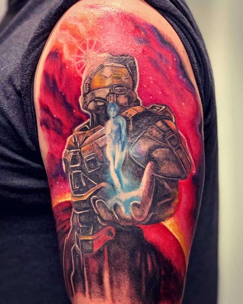 Vivid Halo tattoo of Master Chief holding Cortana’s hologram, set against a fiery red cosmic background, inked on the upper arm.