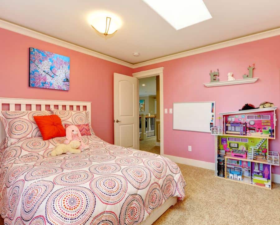 pink bedroom with pattern bedspread and dolls house