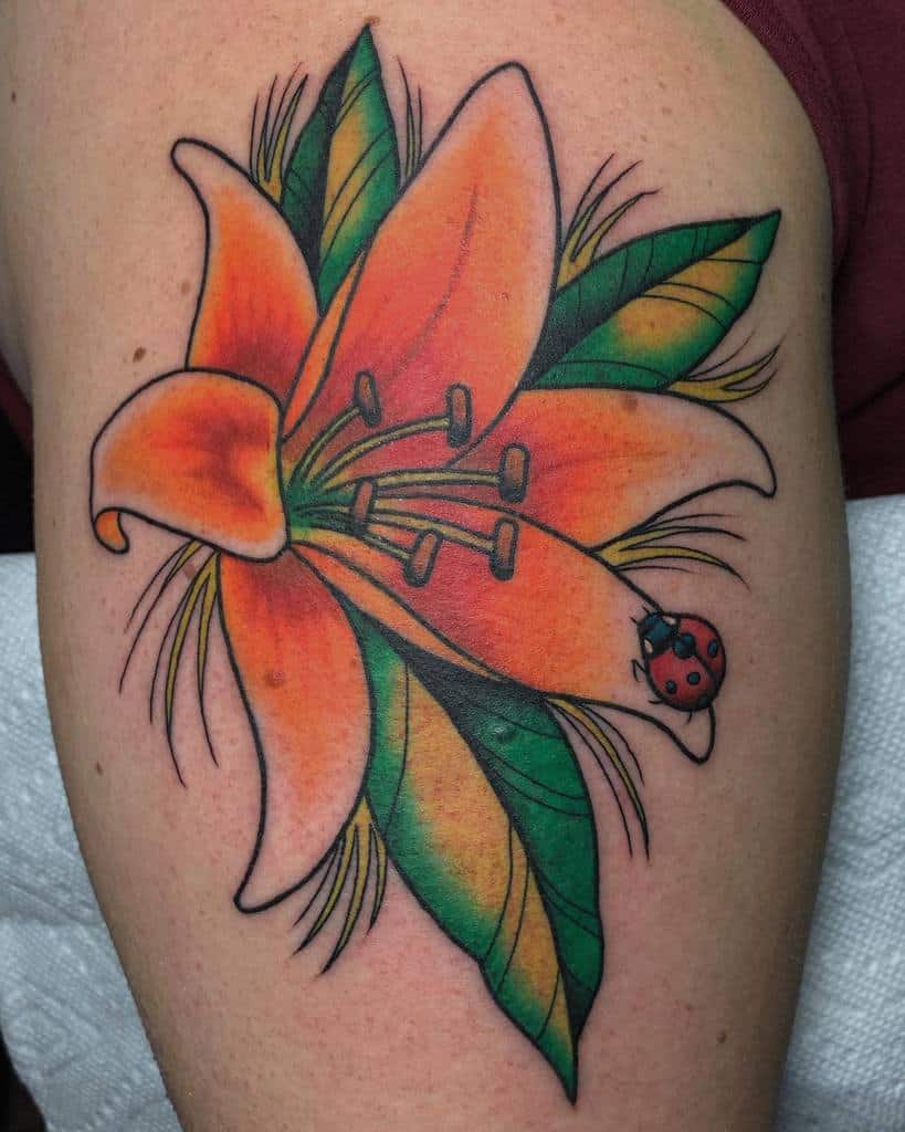 Vibrant tattoo of an orange lily with bold green leaves and a tiny ladybug, blending realism and traditional tattoo style