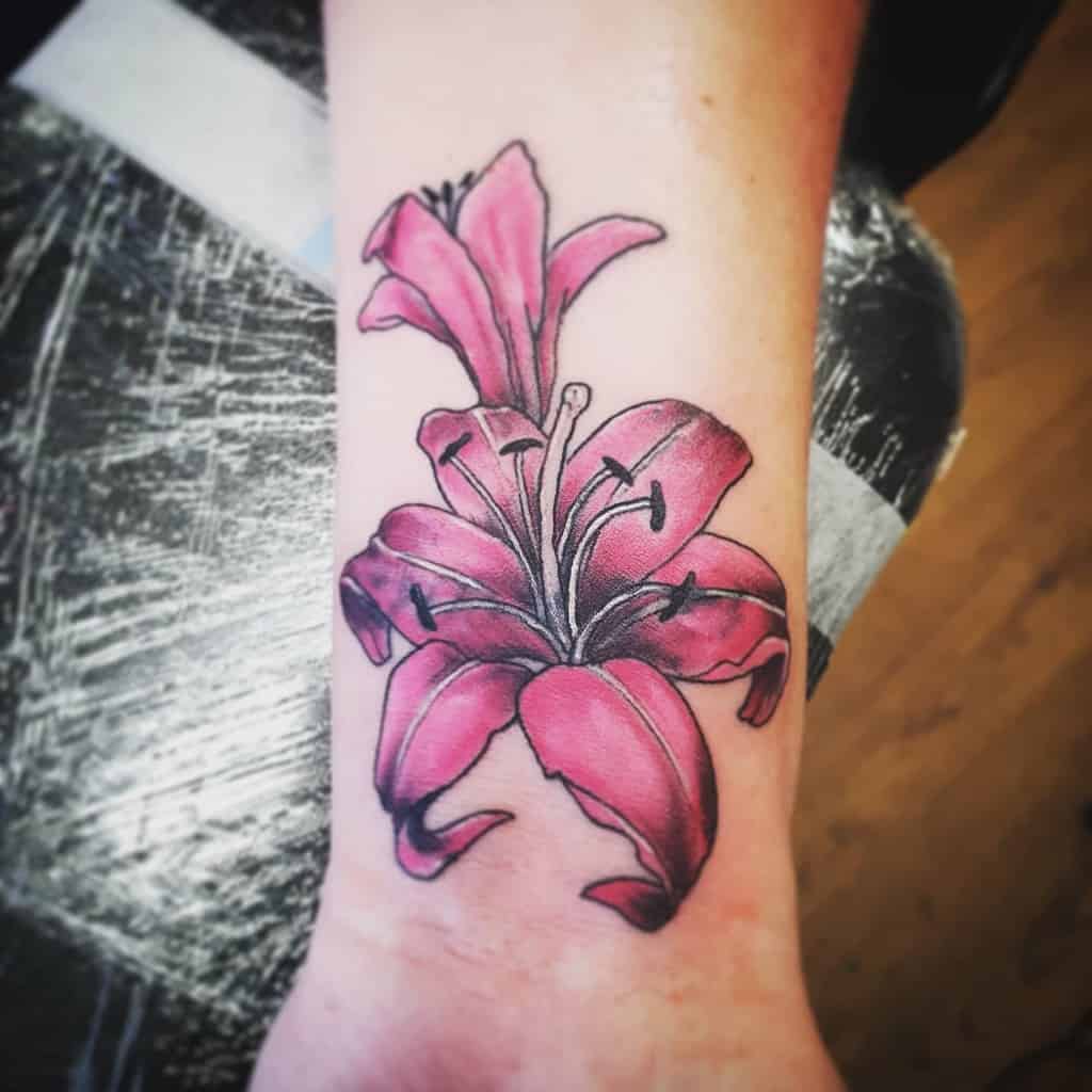 Bold tattoo of a vibrant pink lily with rich shading and fine black outlines, symbolizing beauty, femininity, and personal growth