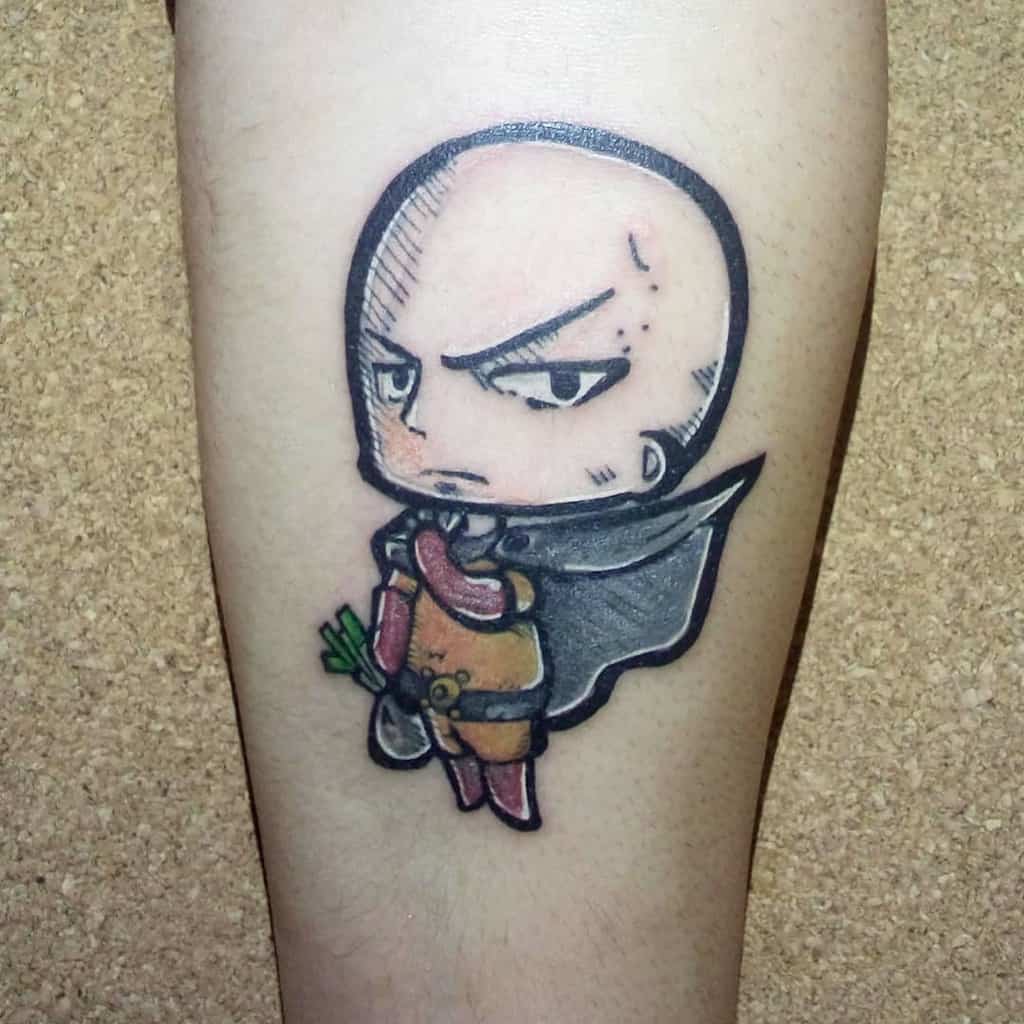 A chibi-style tattoo of Saitama from One Punch Man with a serious expression, holding a grocery bag with vegetables and wearing his cape