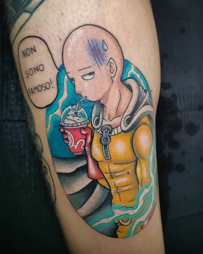 A colorful tattoo of Saitama from One Punch Man sipping a drink with a tired expression, featuring the phrase "Non sono famoso!"