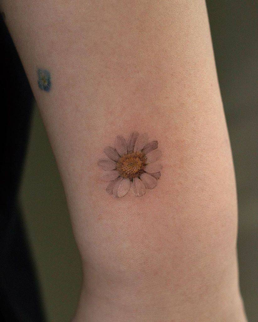 Wrist tattoo tiny color yellow and white daisy