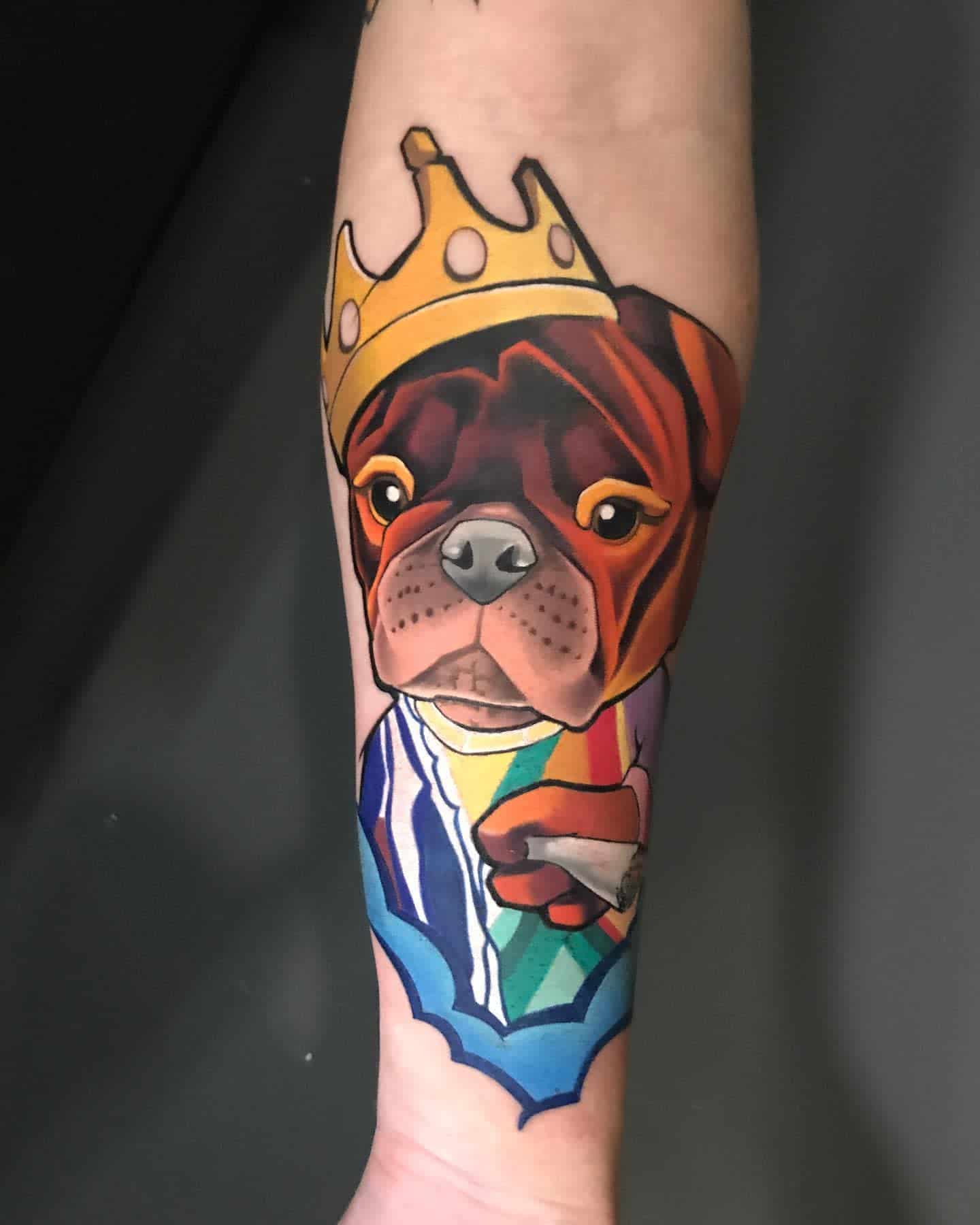 Tattoo of a dog wearing a crown wearing vibrant colors and geometric shapes shirt holding a stick of cigarette