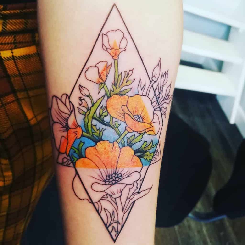 A geometric tattoo on an arm features vibrant orange flowers and green leaves within a diamond shape