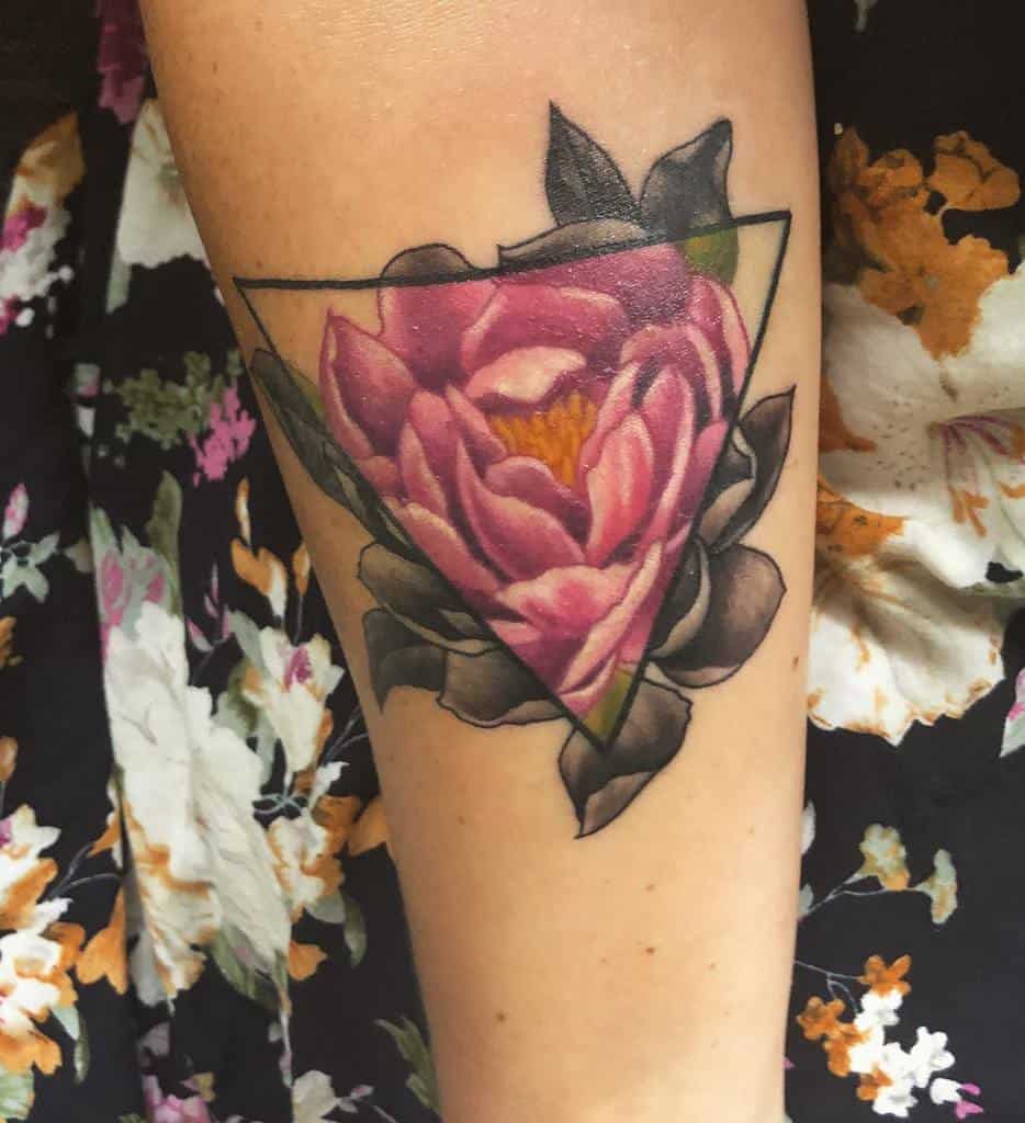 Floral tattoo with a pink flower in a triangle on a forearm
