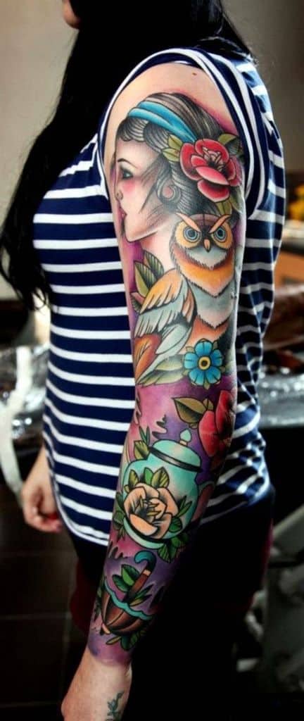 Vibrant full-sleeve tattoo featuring a gypsy woman, a detailed owl, and colorful floral elements with a bold purple background.
