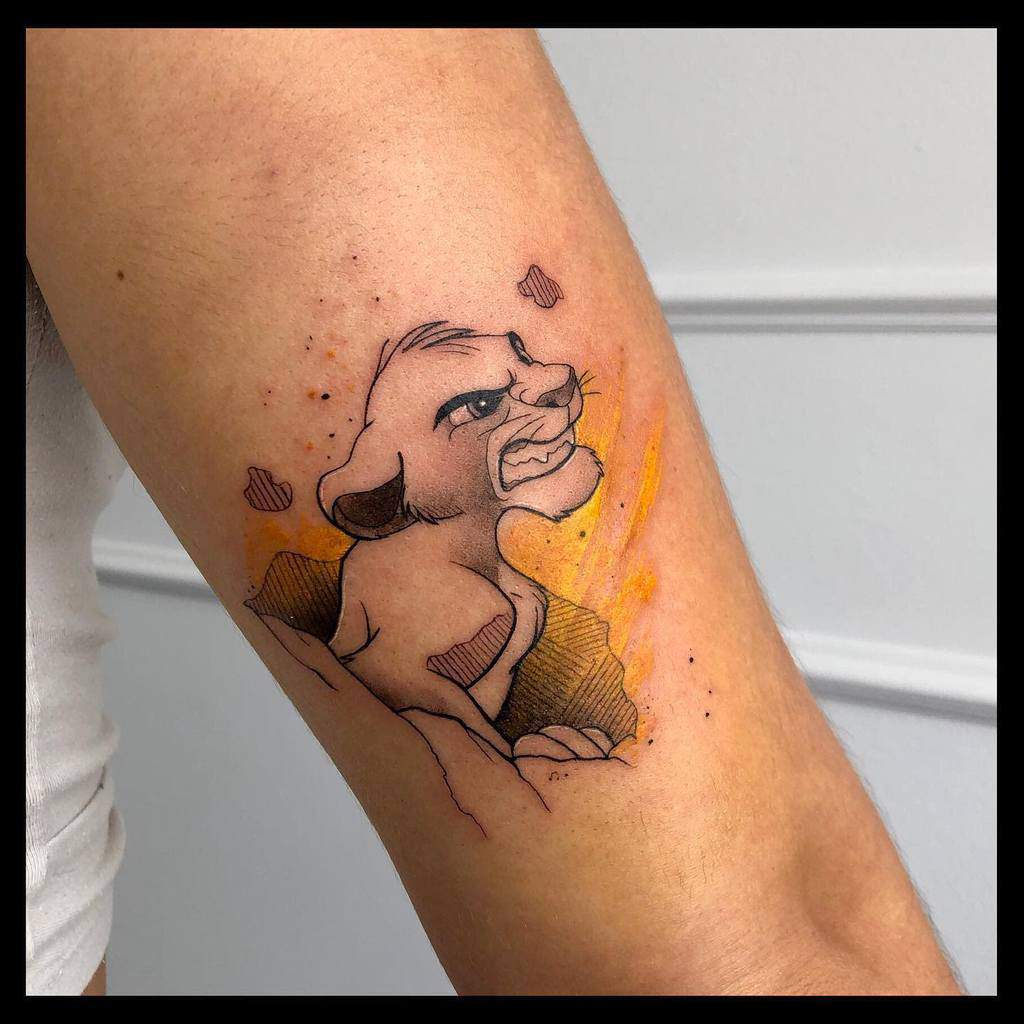 Bold tattoo of Simba as a cub with a fierce expression, accented with vibrant orange splashes for a dramatic effect