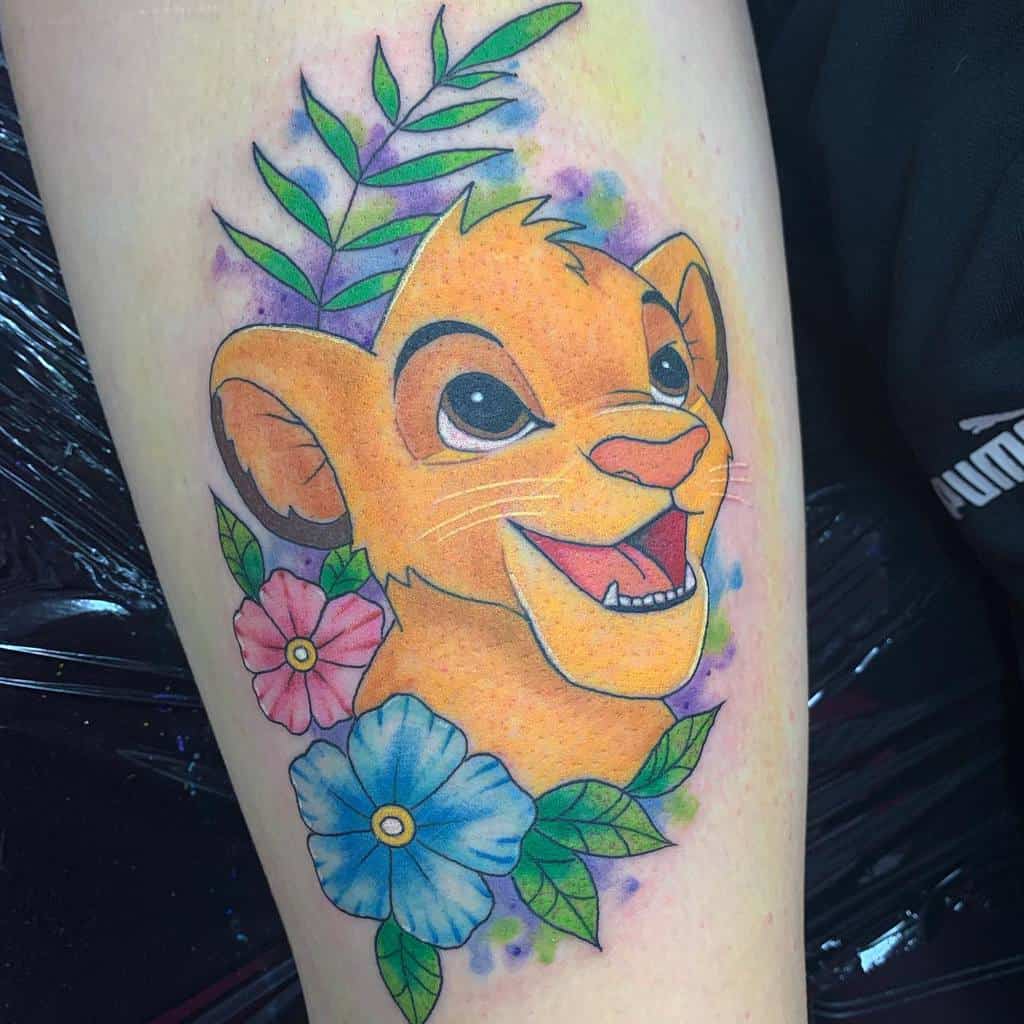 Colorful Simba cub tattoo surrounded by vibrant flowers and greenery, capturing his joyful and playful personality