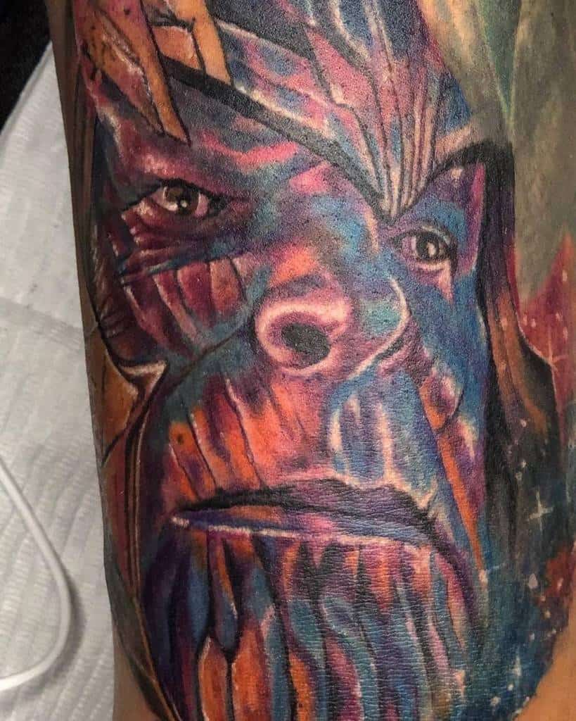 A vibrant tattoo of Thanos, showcasing his face with bold, colorful shading and intricate details, using a mix of reds, blues, and yellows