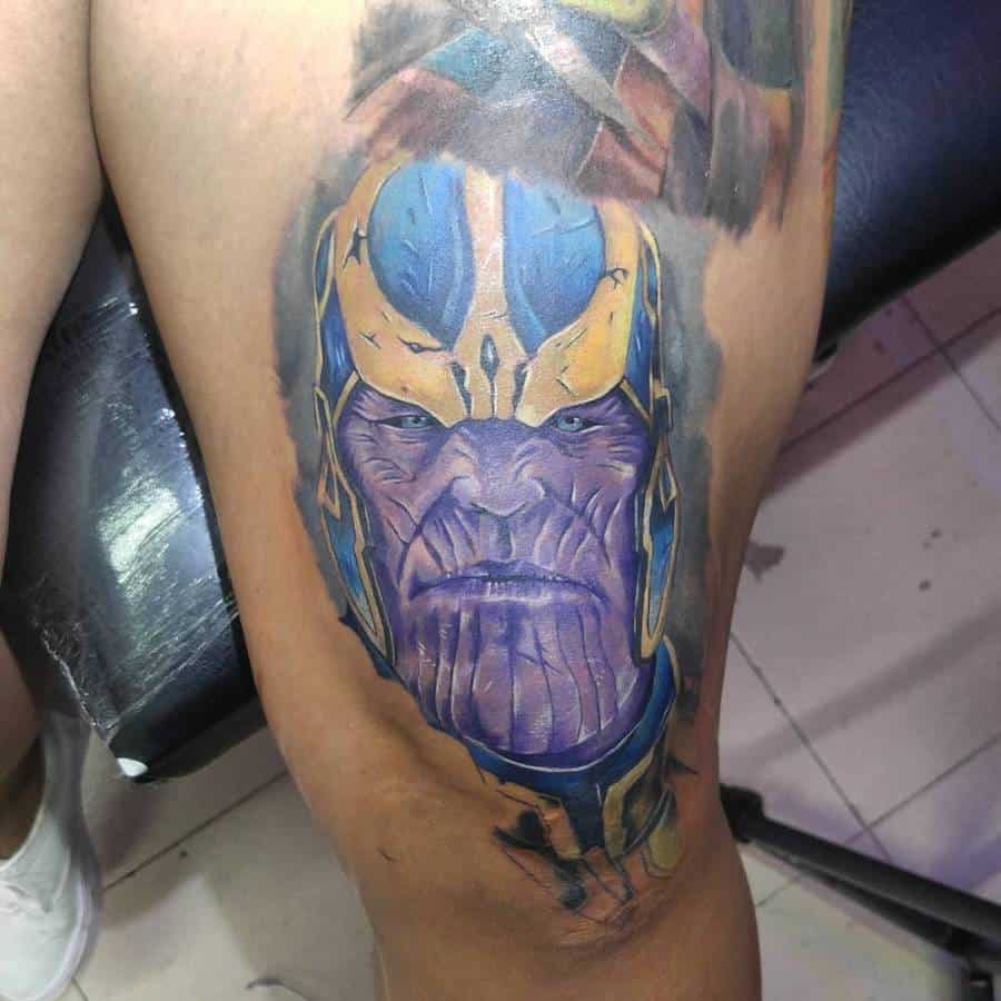 A colorful tattoo of Thanos, showcasing his stern expression with detailed shading on his purple skin and a vibrant blue and yellow helmet