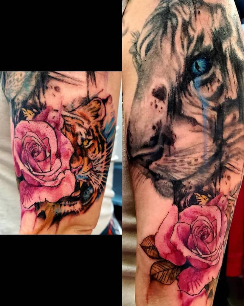 Tattoo of a majestic tiger with a striking blue eye and a delicate pink rose, gracefully inked on a person's upper arm